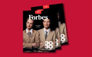Forbes magazine cover with three women in beige business suits, white Forbes logo, and red 'Special Issue' labels, tilted against a red background.