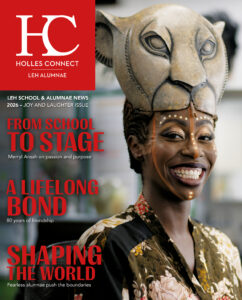 Magazine cover: a woman smiling wearing a carved animal mask on the right, with bold red typography block on the left.